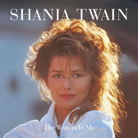 Close-up portret van Shania Twain met warrig haar, kijkend naar de camera, met een witte badjas aan.