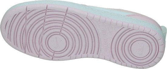 Onderkant van roze Nike sneakers met cirkelvormig profiel en Nike logo.