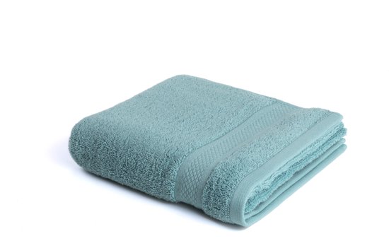 Une serviette bleu clair pliée avec un motif détaillé sur le bord, sur fond blanc.