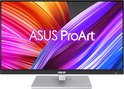 ASUS ProArt monitor met een levendige abstracte achtergrond op het scherm en een zilverkleurige standaard.