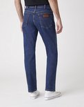Man in spijkerblauwe Wrangler spijkerbroek, recht model, gezien van achteren.