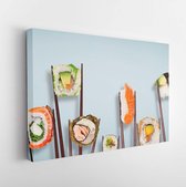 Traditional japanese sushi pieces placed between chopsticks, separated on light blue pastel background. Very high resolution image. - Modern Art Canvas - Horizontal - 1090150760 -