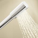 Close-up van een chroomkleurige handdouche met straal water.