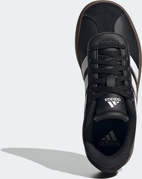 Zwarte kindersneaker van adidas, bovenaanzicht met witte strepen en bruine zool.