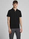 Man draagt een zwarte polo met knopen en een geborduurd logo, en een grijze broek.