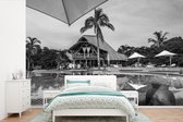Behang - Fotobehang Tropische villa met groot zwembad - zwart-wit - Breedte 600 cm x hoogte 400 cm