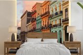 Behang - Fotobehang Oude auto's voor de kleurrijke gebouwen van Cuba - Breedte 350 cm x hoogte 350 cm