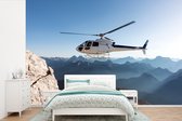 Behang - Fotobehang Helikopter boven gebergtes - Breedte 330 cm x hoogte 220 cm