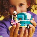 Kind houdt LEGO Friends bubbelthee kar met scooter en poppetje vast, met gele achtergrond.