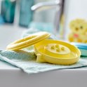 Een geel, nat LEGO DUPLO drijvend badspeelgoed onderdeel en ring liggen op een lichtblauwe handdoek.