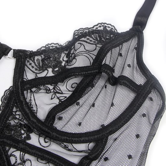Close-up van een zwarte kanten bodysuit met stippen, gedetailleerde kanten randen en verstelbare bandjes.