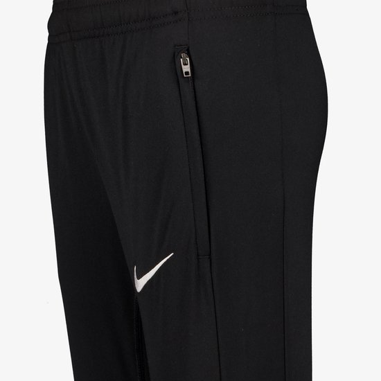 Zijzak met rits en witte Nike swoosh op een zwarte trainingsbroek.