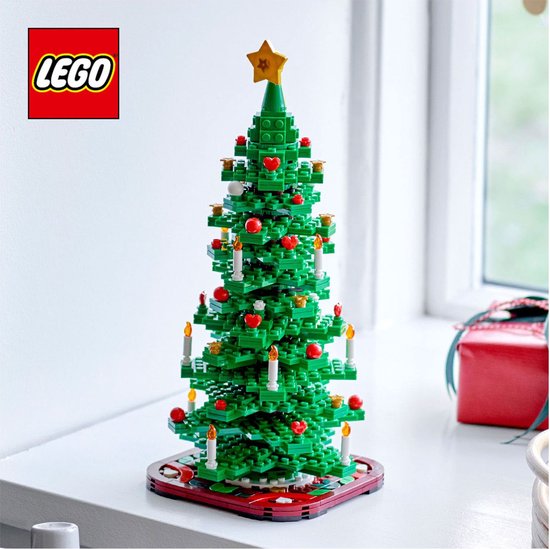 Sapin de Noël LEGO vert avec boules rouges, bougies blanches et étoile jaune sur le rebord de fenêtre.