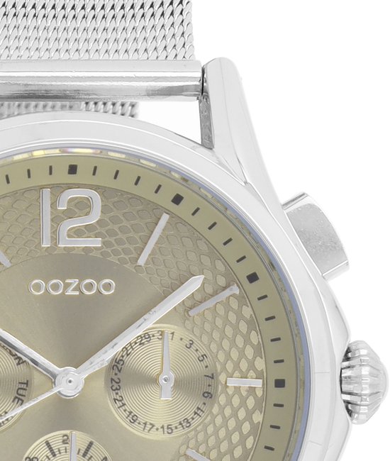 Montre argentée avec cadran doré à motif à chevrons et bracelet en maille argentée.