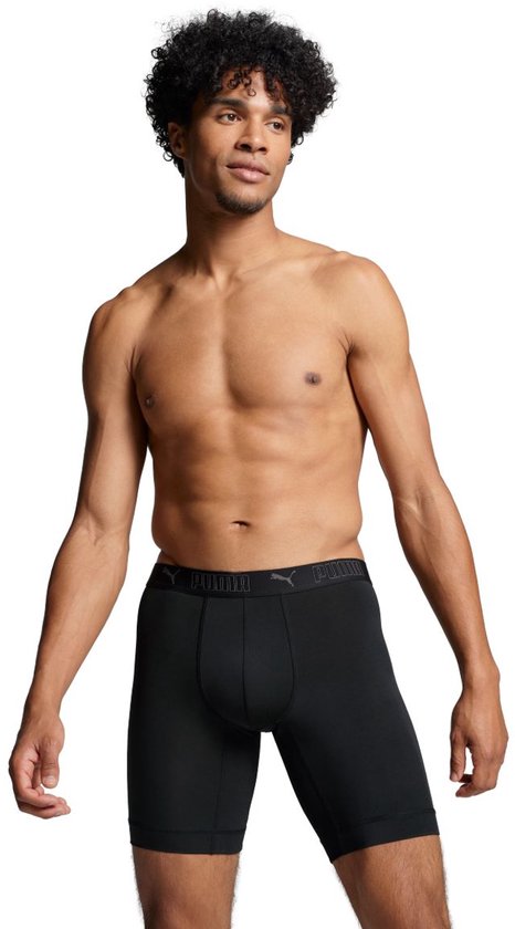 Man, van voren, draagt zwarte boxer briefs met Puma-logo op de tailleband. Zijn lichaam is zichtbaar vanaf de borst.