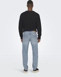 Achterkant van een man met een trui en lichtblauwe jeans, rechte pasvorm, normale taille.
