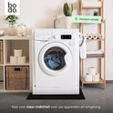 Wasmachine op een zwarte anti-trillingsmat in een badkamer.