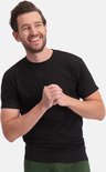 Een lachende man in een zwart T-shirt met ronde hals en een groene onderbroek.