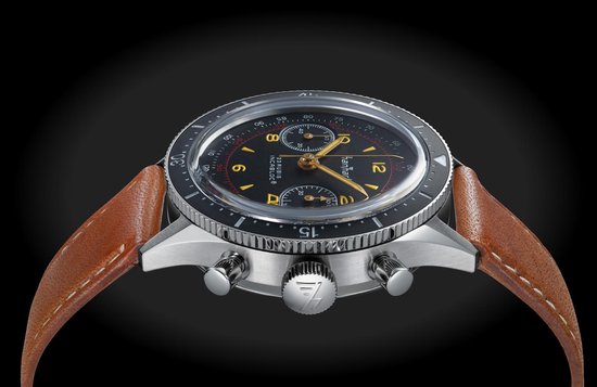 Chronograaf met zwarte wijzerplaat, rode accenten en een bruin lederen band.