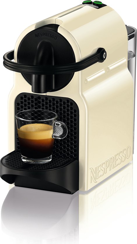 Machine à café à capsules Nespresso Inissia crème avec une tasse d'expresso.