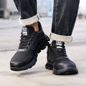 Zicht op de voeten in zwarte werksneakers met veters, mesh bovenkant en robuuste zool.