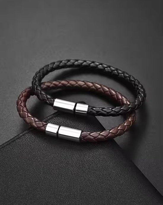 Twee gevlochten leren armbanden, zwart en bruin, met zilverkleurige magneetsluitingen.