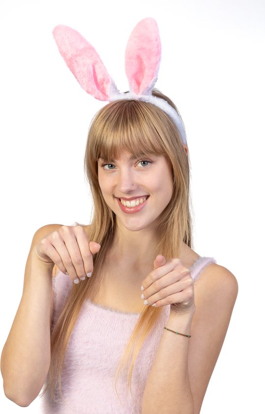 Vrolijke vrouw met blonde haren, draagt een konijnenoren haarband, wijst naar voren.