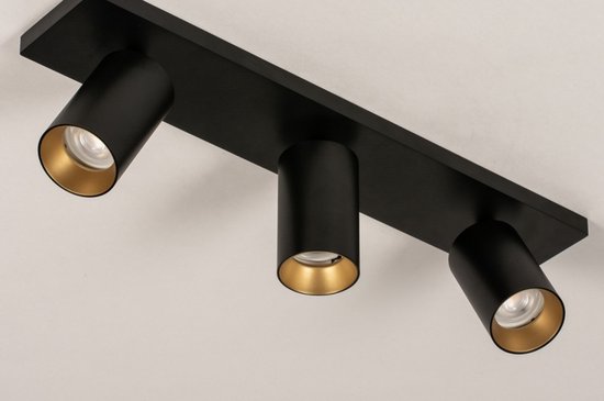 Plafonnier noir avec trois spots à intérieur doré, montés sur une barre noire.