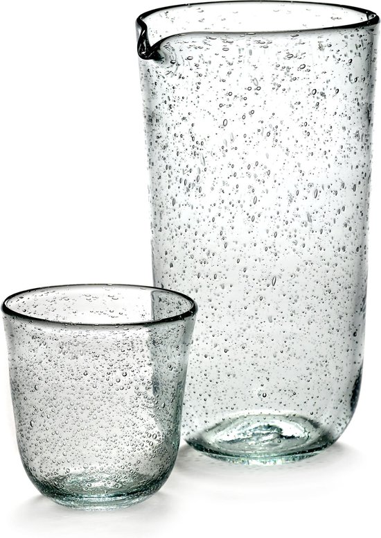 Een karaf en een drinkglas met luchtbelletjes in het glas.