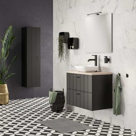 Salle de bain moderne avec meuble noir, carrelage aspect marbre, accessoires noirs et tapis géométrique.
