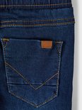 Detail achterzak spijkerbroek met naamlabel.