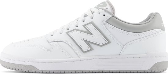 Witte lage sneaker van New Balance met grijze accenten en een groot grijs 'N' logo op de zijkant.
