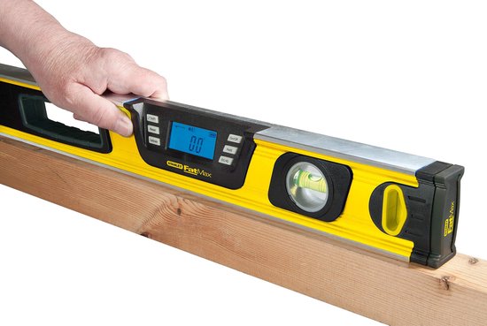 Hand houdt een gele Stanley FatMax waterpas op een houten balk.