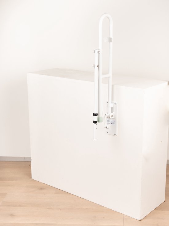 Opklapbare witte toiletbeugel met steunpoot, tentoongesteld op een witte kubus.
