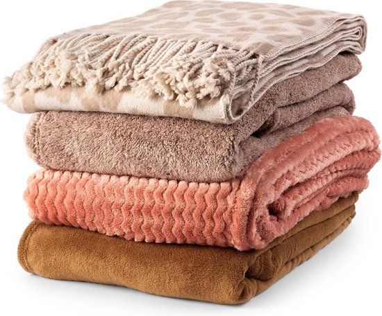 Stapel van 5 dekens in aardetinten, van boven naar beneden: beige luipaardprint met franjes, taupe, lichtbruin, zalmroze zigzag, donkerbruin.