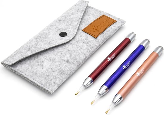 Trois stylos de peinture diamant Diamond Hobbies rouge, bleu et couleur cuivre, à côté d'un étui gris.