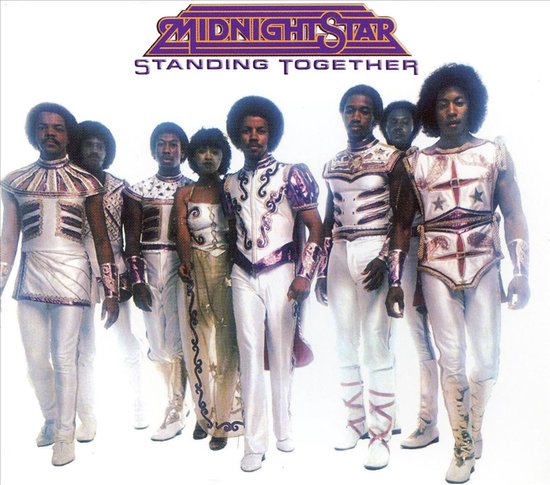 Albumhoes 'Standing Together' van Midnight Star met een groep van zeven mensen in glinsterende, futuristische outfits met opvallende details.