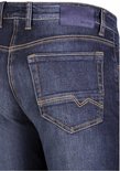 Close-up van de achterzak van een donkerblauwe jeans met oranje stiksels en een blauw merklabel.