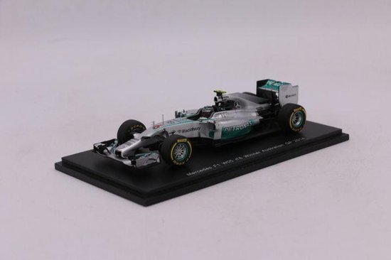 Zilveren Mercedes F1 auto met PETRONAS logo's en groene accenten, zijkant zichtbaar.
