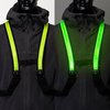 Gele LED-banden vormen een X op de borst van een zwart jack. De banden lichten op in het donker.
