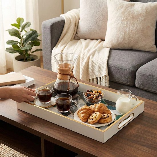 Wit dienblad met geometrisch marmerpatroon in groen, grijs en wit, met gouden rand. Geserveerd met koffie, croissants en fruit.