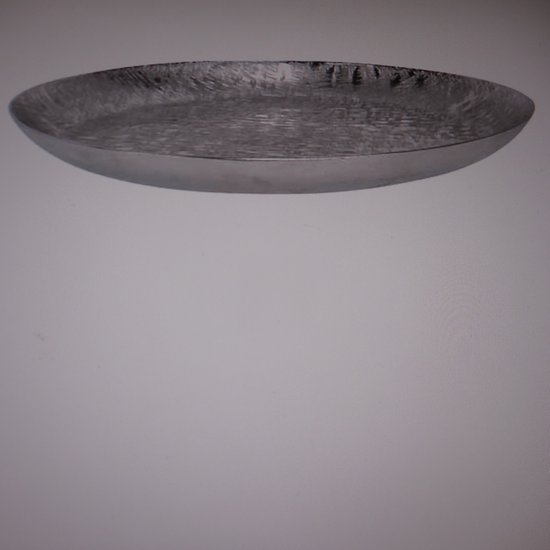 Zilverkleurige, ovale schaal van aluminium met een gehamerd, onregelmatig patroon.