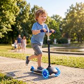 Jongetje rijdt op een zwarte step met blauwe, verlichte wielen in een park.