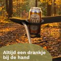 Zwarte klapstoel met bekerhouder in de armleuning, met blikje bier erin, in een bosrijke omgeving.
