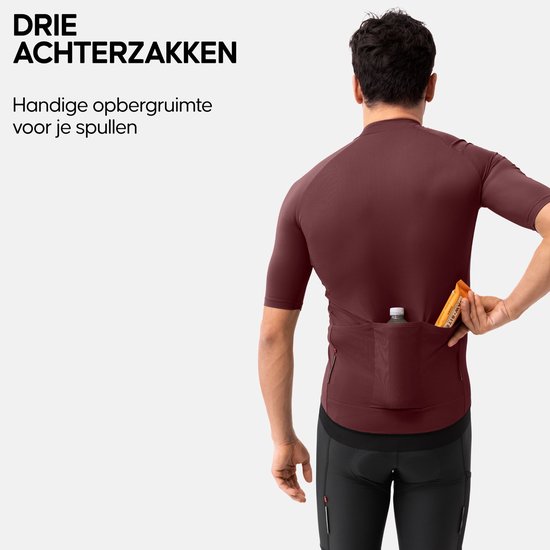 Man met bordeaux fietsshirt met korte mouwen, die een flesje en een energiereep uit de drie achterzakken haalt.
