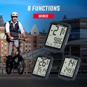 Een man met fietshelm op een vouwfiets, met drie zwarte Sigma fietscomputers. De computers tonen verschillende snelheden en rijdtijden.