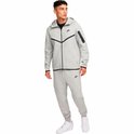 Man in een compleet grijze Nike Tech Fleece trainingspak met zwart accent.