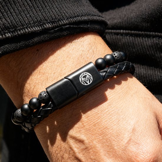 Zwarte gevlochten lederen armband met kralen van zwarte lavasteen en mat zwart, met zwarte gespsluiting.