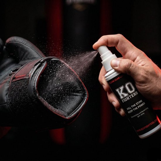 Hand spuit KO FIGHTERS desinfecterende spray op een zwarte bokshandschoen.