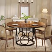 Ronde eettafel met bruin houten blad met visgraatpatroon, geplaatst in een eetkamer met rieten stoelen.